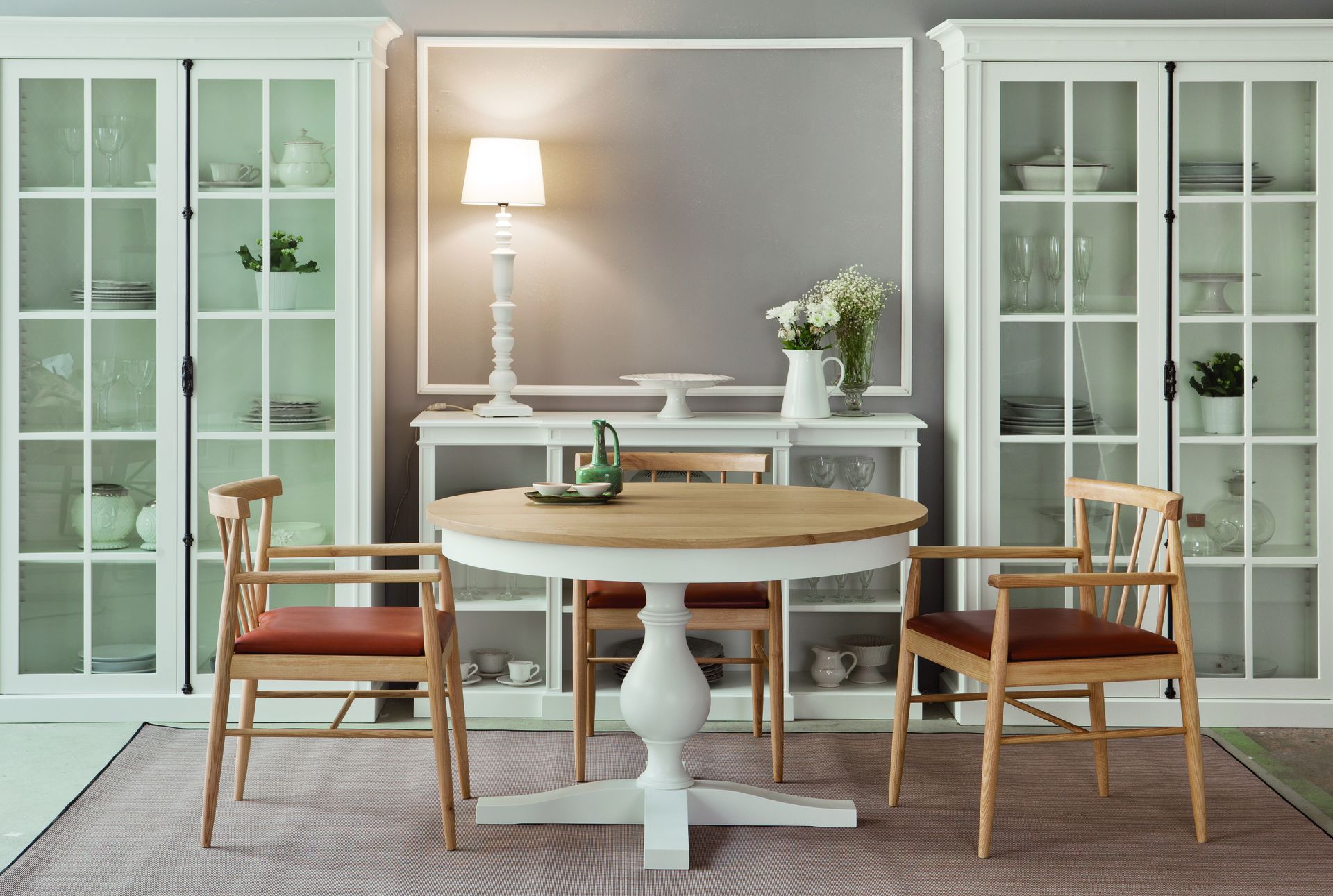 Conjunto de sala de jantar com mesa redonda de pé central, cadeiras com assento estofado e armários vitrine - Homes in Heaven
